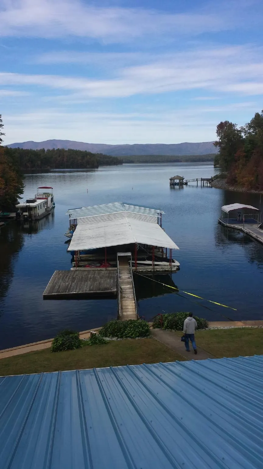 View across a lake from a newly installed blue metal roof in Clarendon