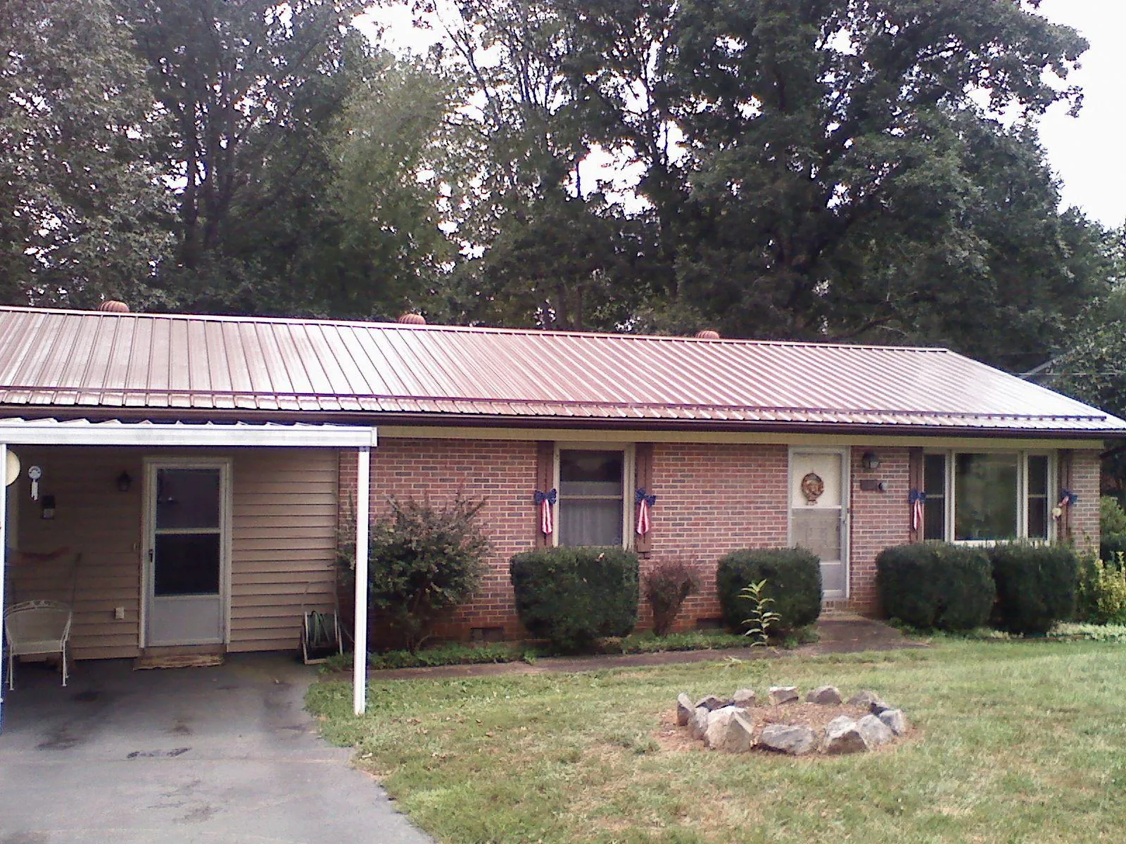 Bronze metal roof and carport on a brick ranch home — Roof Repair work by our crew in Clarendon