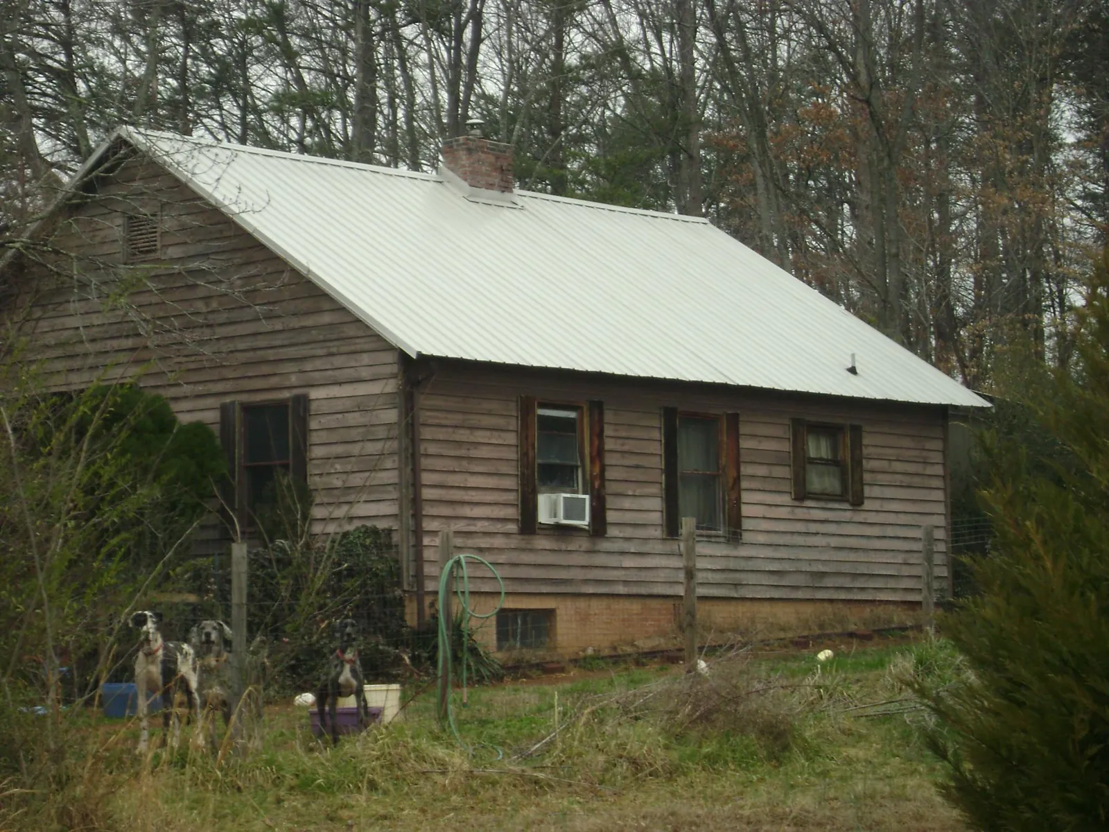 White metal roof on an old wood sided farmhouse, from a Metal Roof Installation job in Clarendon